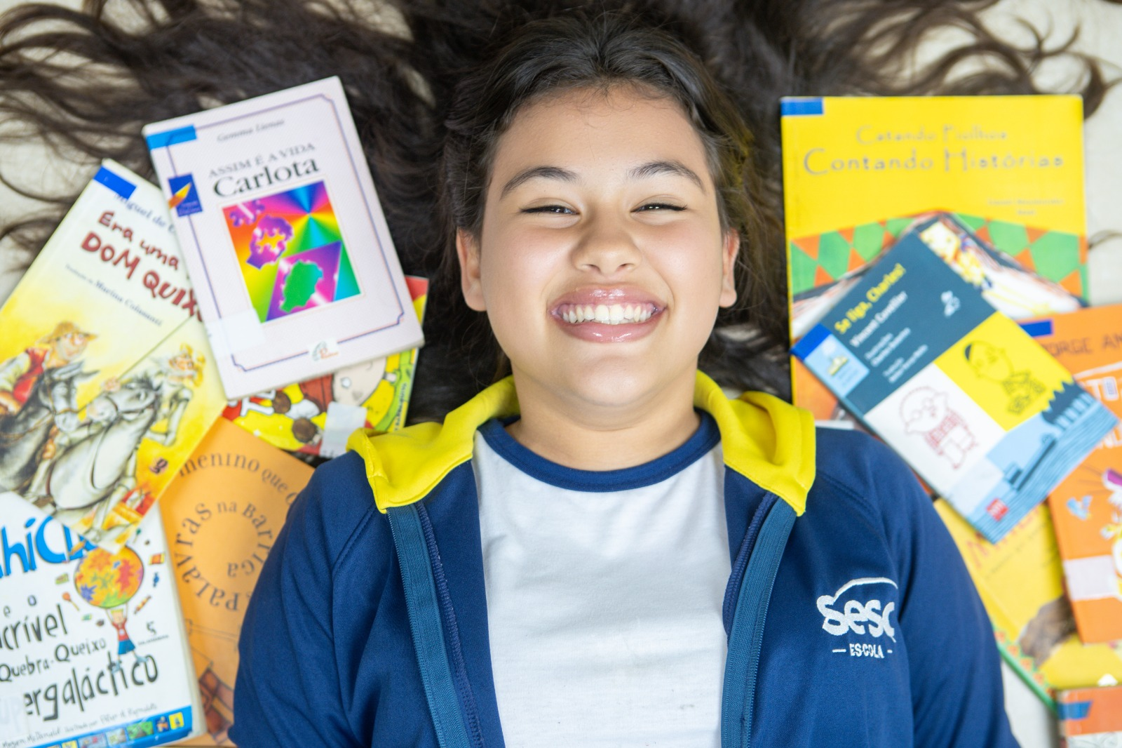 Júlia, entre seus livros e sonhos na Escola Sesc / Foto: Alexandre Lago
