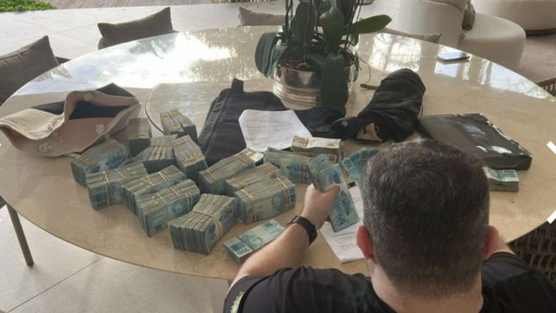  Agente da PF conta dinheiro encontrado na casa de um dos dirigentes do Banco Master — Foto: Divulgação/PF 
