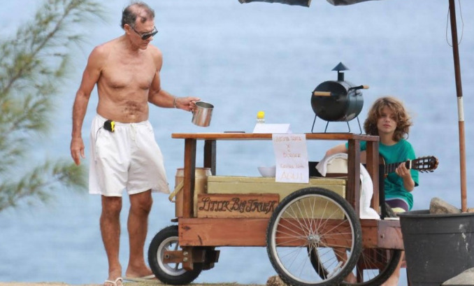 Foi fotografado algumas vezes vendondo sanduíche na praia para garantir o sustento. Imagem: internet.