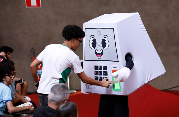 A mascote integra uma estratégia de comunicação da Justiça Eleitoral para reforçar a importância do voto, sobretudo entre novos eleitores.