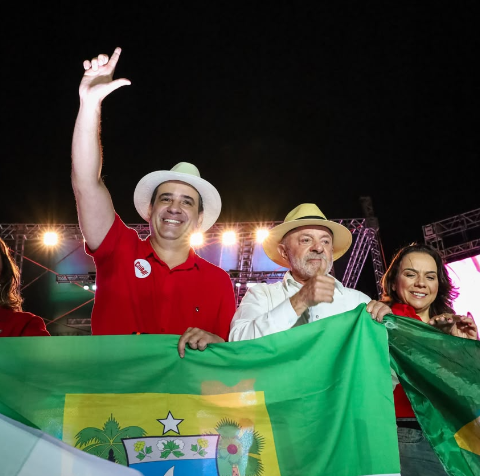 Cadu de Lula em aceno aos apoiadores, juntamente com presidente Lula.