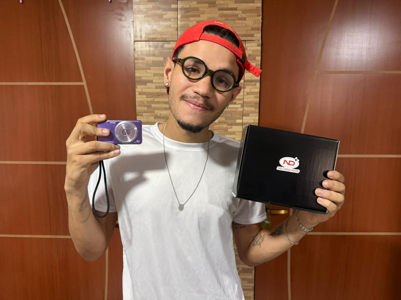 Natanael Paccelle exibe uma das câmeras digitais comercializadas pela NEI DIGICAMS e a embalagem personalizada do negócio criado em Natal. Foto: Cedida/Acervo Pessoal